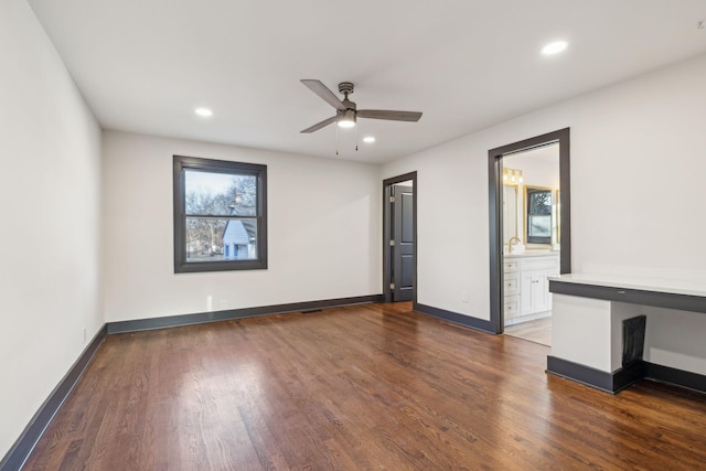 spare room featuring ceiling fan and dark hardwood / wood-style floors