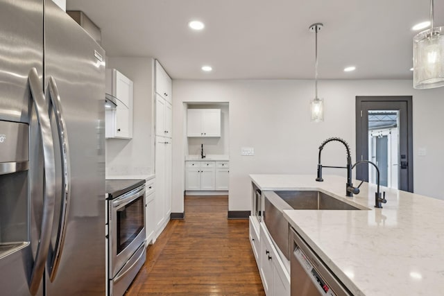 kitchen featuring white cabinets, pendant lighting, and appliances with stainless steel finishes