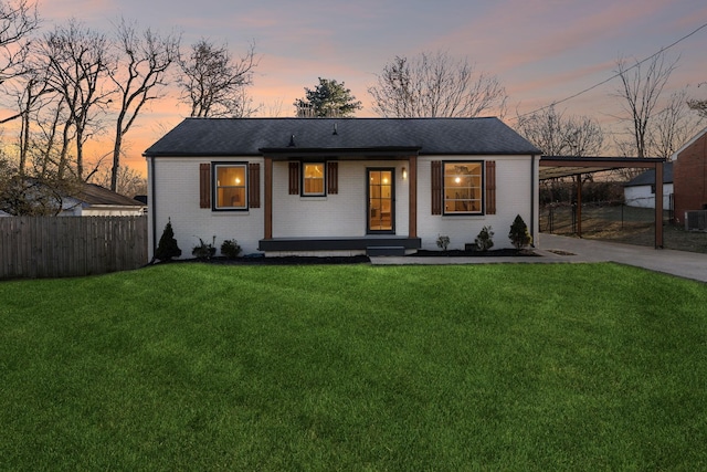 view of front facade with cooling unit, a carport, and a yard