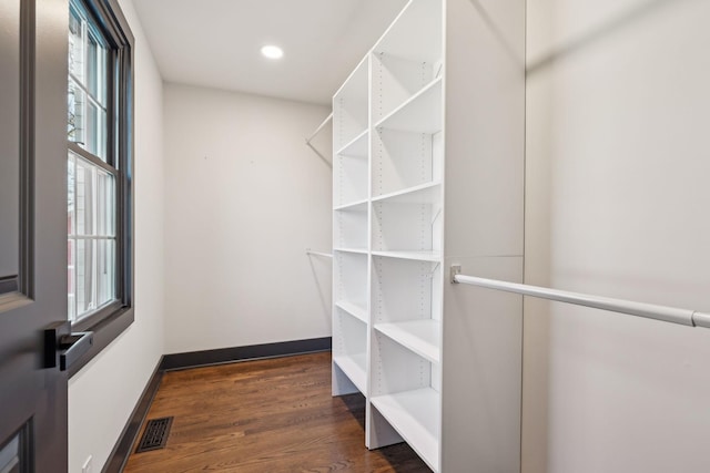 walk in closet with dark hardwood / wood-style flooring