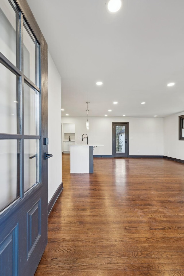 unfurnished living room with sink and dark hardwood / wood-style floors