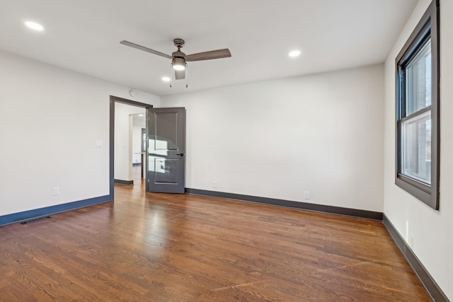 spare room featuring ceiling fan and dark wood-type flooring