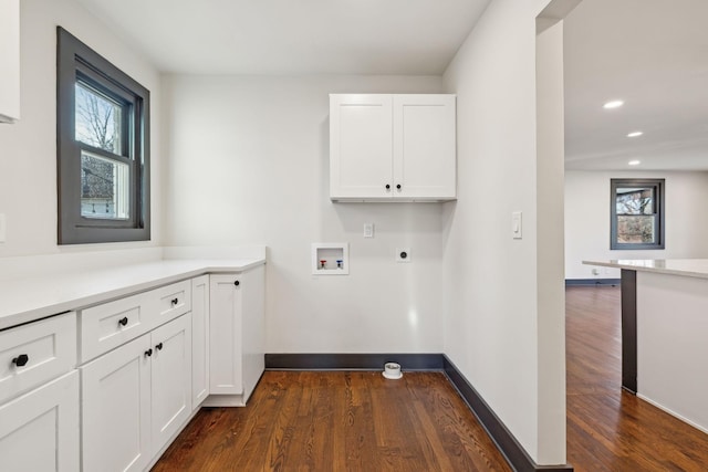 laundry room featuring dark hardwood / wood-style floors, hookup for an electric dryer, hookup for a washing machine, and cabinets