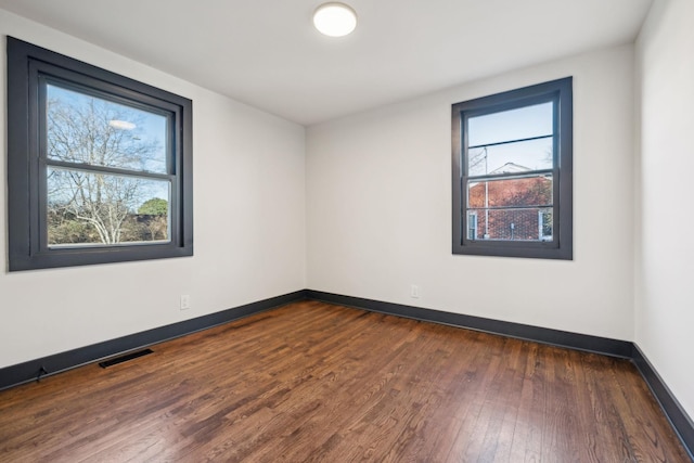 spare room with dark hardwood / wood-style floors