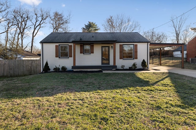 view of front facade with a front lawn, cooling unit, and a carport