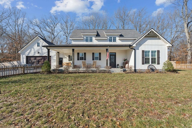 modern inspired farmhouse featuring a garage, covered porch, and a front yard