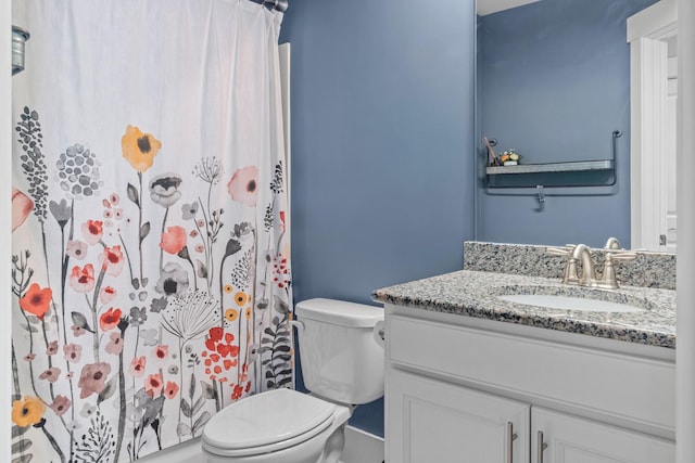 bathroom featuring toilet, vanity, and a shower with curtain