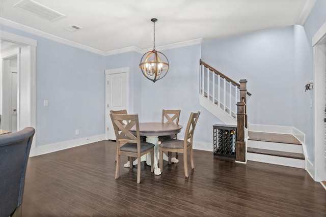 dining area featuring dark hardwood / wood-style flooring, crown molding, and a chandelier