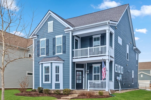 view of front of house with a balcony, a porch, and a front lawn