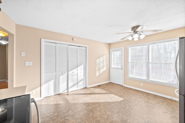 unfurnished living room featuring a textured ceiling and ceiling fan