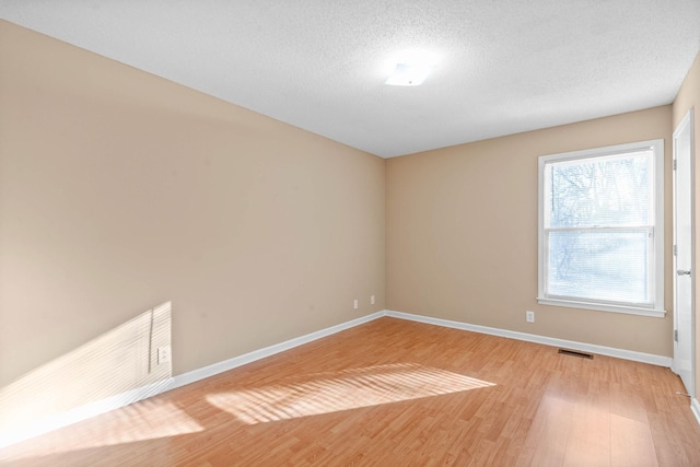 unfurnished room featuring hardwood / wood-style floors and a textured ceiling