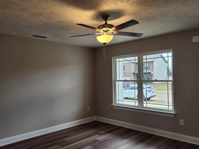 empty room featuring ceiling fan, a textured ceiling, and dark hardwood / wood-style flooring