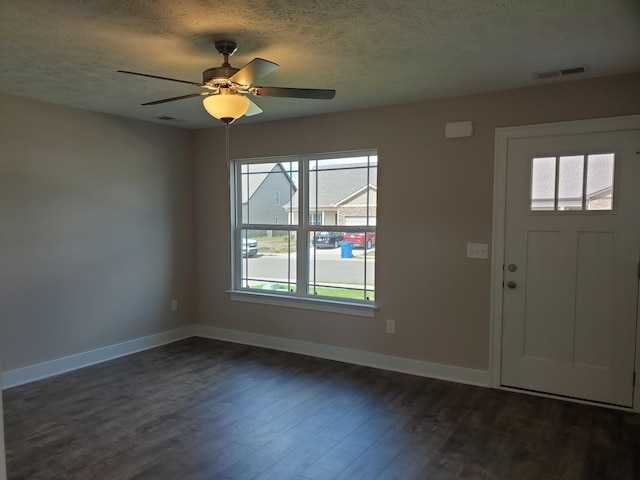 foyer featuring ceiling fan, dark wood-type flooring, and a textured ceiling