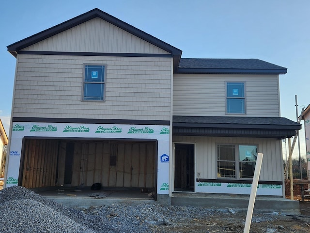 view of front facade with a garage and roof with shingles