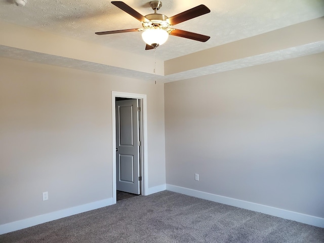 carpeted spare room with a textured ceiling and ceiling fan