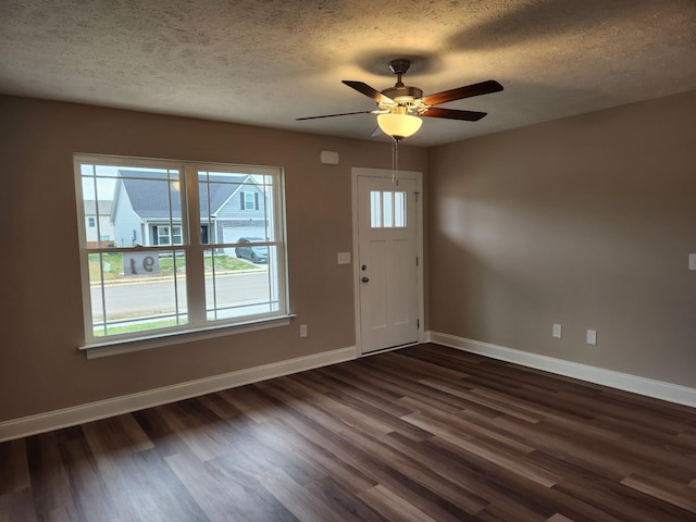 foyer entrance with ceiling fan, a textured ceiling, and dark hardwood / wood-style floors