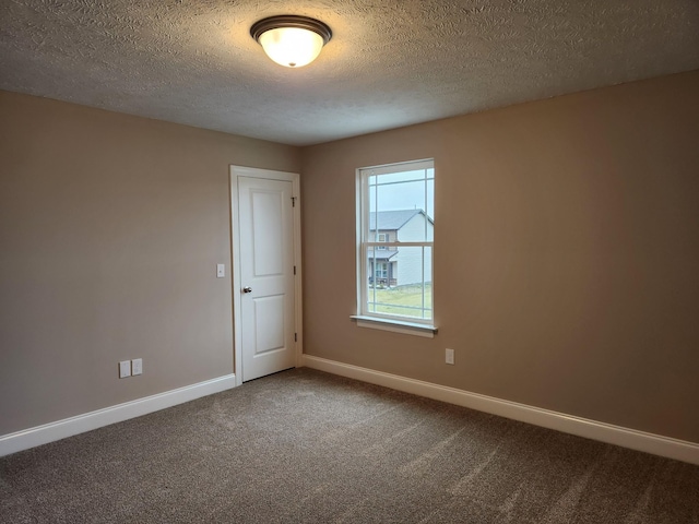 carpeted spare room featuring a textured ceiling