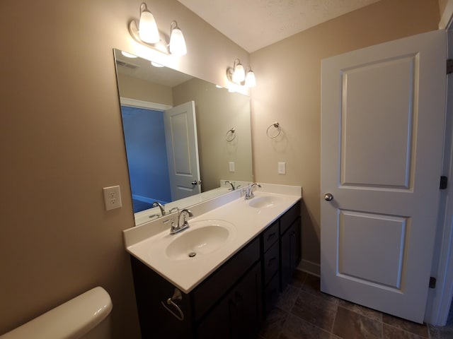 bathroom featuring toilet and vanity