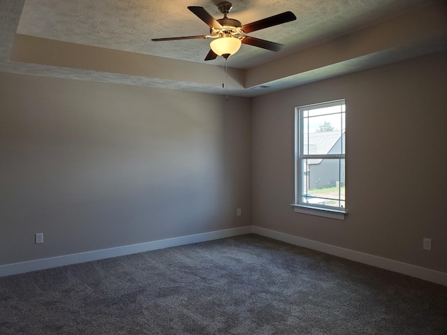 spare room with ceiling fan, a textured ceiling, carpet, and a raised ceiling