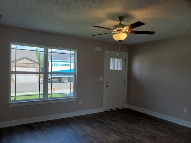 entryway with ceiling fan, a wealth of natural light, dark hardwood / wood-style flooring, and a textured ceiling