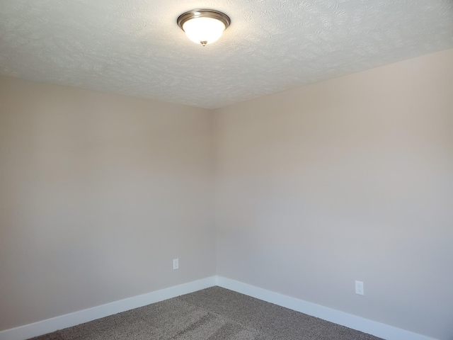 carpeted spare room featuring a textured ceiling