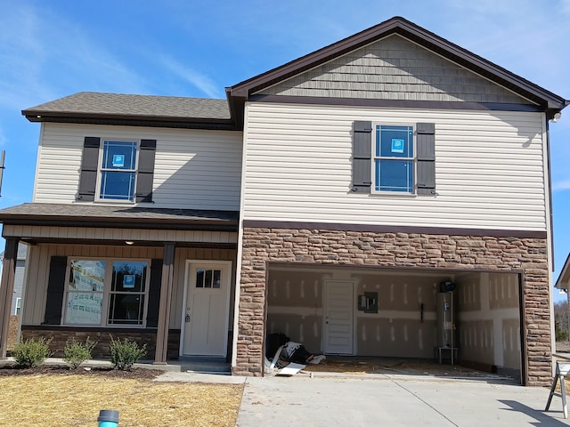 view of front facade featuring a garage, stone siding, water heater, and concrete driveway