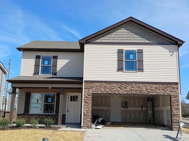 view of front of house featuring a garage, stone siding, concrete driveway, and roof with shingles