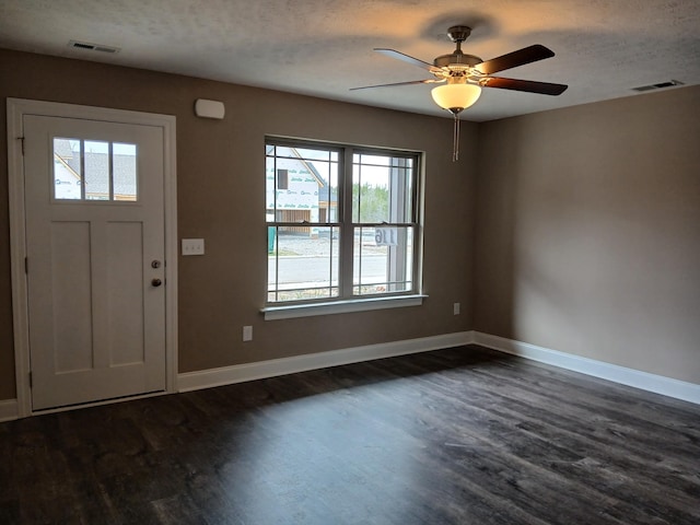 foyer featuring visible vents, baseboards, and dark wood-style flooring