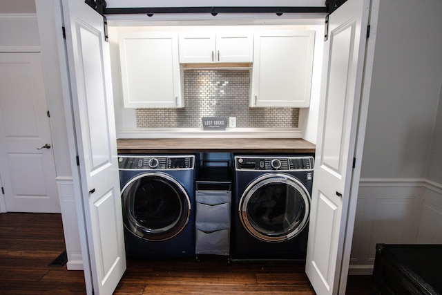 laundry room featuring a barn door, dark hardwood / wood-style floors, and washing machine and clothes dryer