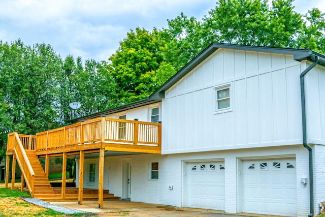 rear view of property with a wooden deck and a garage