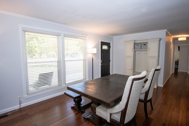 dining area with dark hardwood / wood-style floors and crown molding