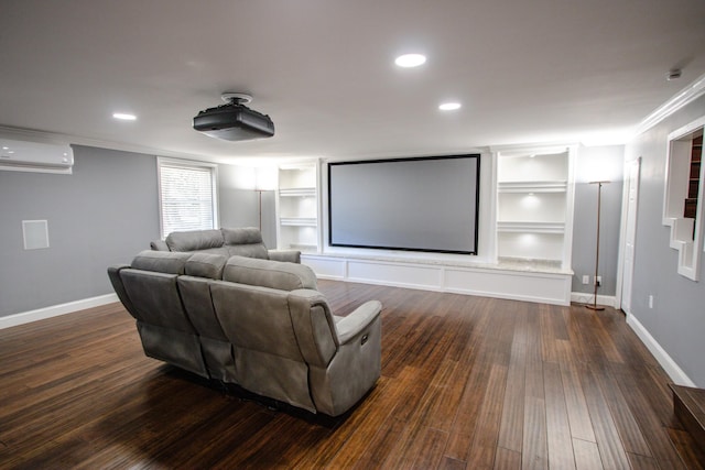 home theater with built in features, dark hardwood / wood-style flooring, ornamental molding, and a wall mounted air conditioner