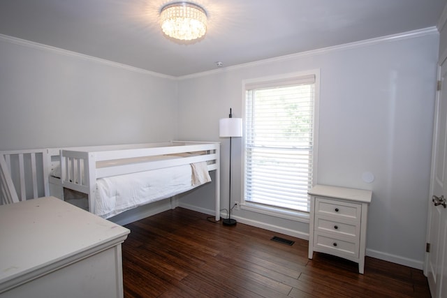 bedroom with dark hardwood / wood-style floors, an inviting chandelier, and ornamental molding