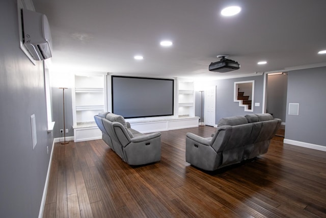 cinema room with built in shelves, dark hardwood / wood-style floors, crown molding, and a wall unit AC