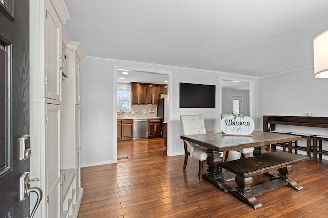 dining area featuring visible vents, crown molding, baseboards, and wood finished floors