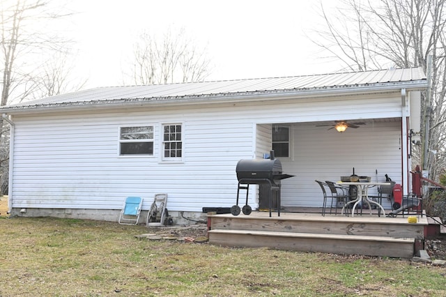 back of property featuring a lawn, ceiling fan, and a deck