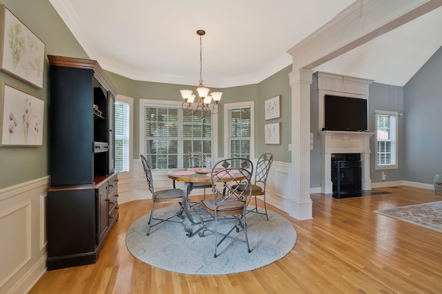 dining space with light hardwood / wood-style floors, crown molding, and a notable chandelier