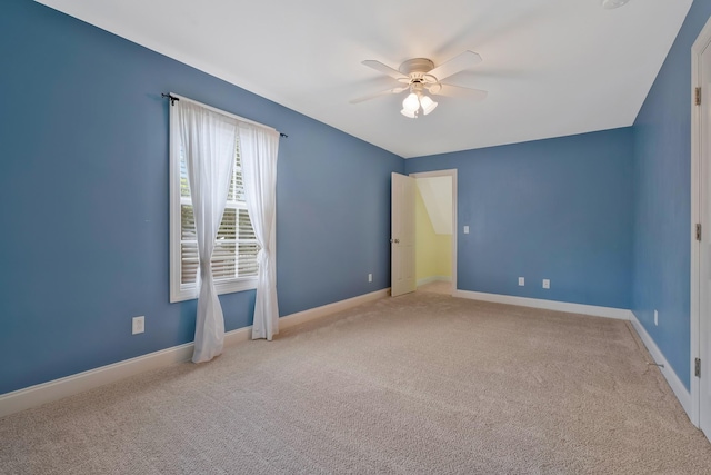 carpeted spare room with ceiling fan