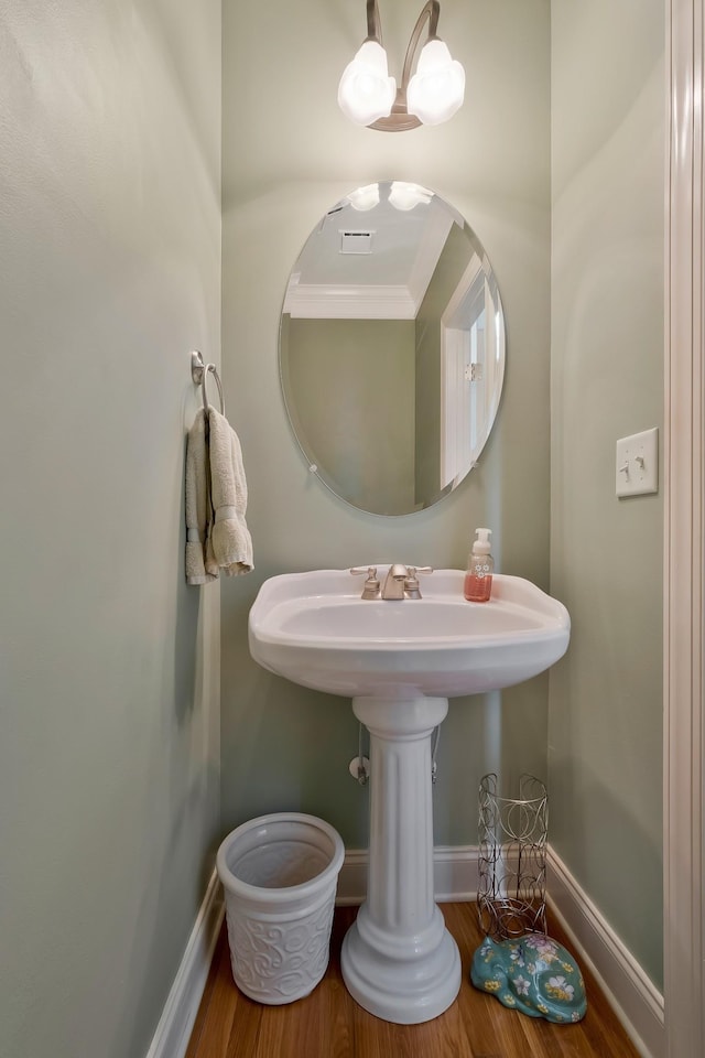 bathroom with a chandelier, ornamental molding, and hardwood / wood-style floors