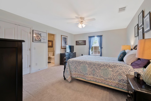 carpeted bedroom featuring ceiling fan and ensuite bath