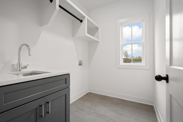 laundry room featuring sink, hookup for a washing machine, and cabinets