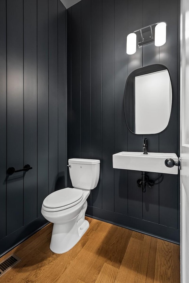 bathroom featuring toilet, wood-type flooring, and sink