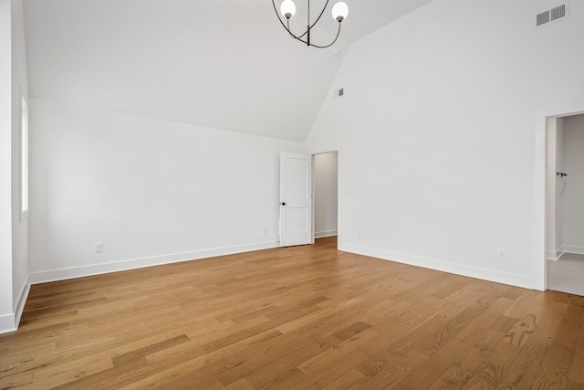 interior space with high vaulted ceiling, a chandelier, and light hardwood / wood-style floors