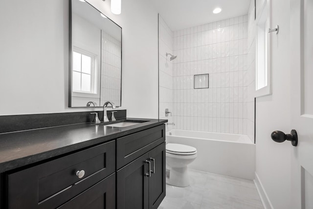 full bathroom featuring toilet, tiled shower / bath combo, and vanity