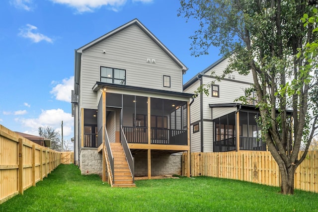 rear view of property with a sunroom and a lawn