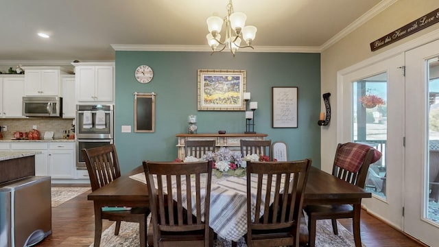 dining space with crown molding, dark hardwood / wood-style floors, and a chandelier