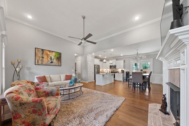 living room with light hardwood / wood-style floors, sink, ornamental molding, and ceiling fan