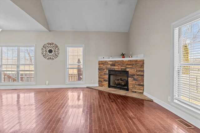 unfurnished living room featuring lofted ceiling, hardwood / wood-style floors, and a fireplace