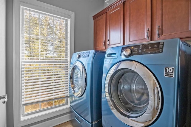 washroom featuring cabinets and washer and clothes dryer