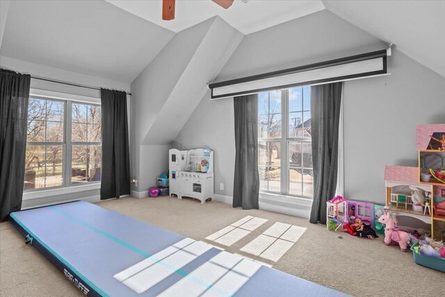 rec room with ceiling fan, lofted ceiling, and light carpet